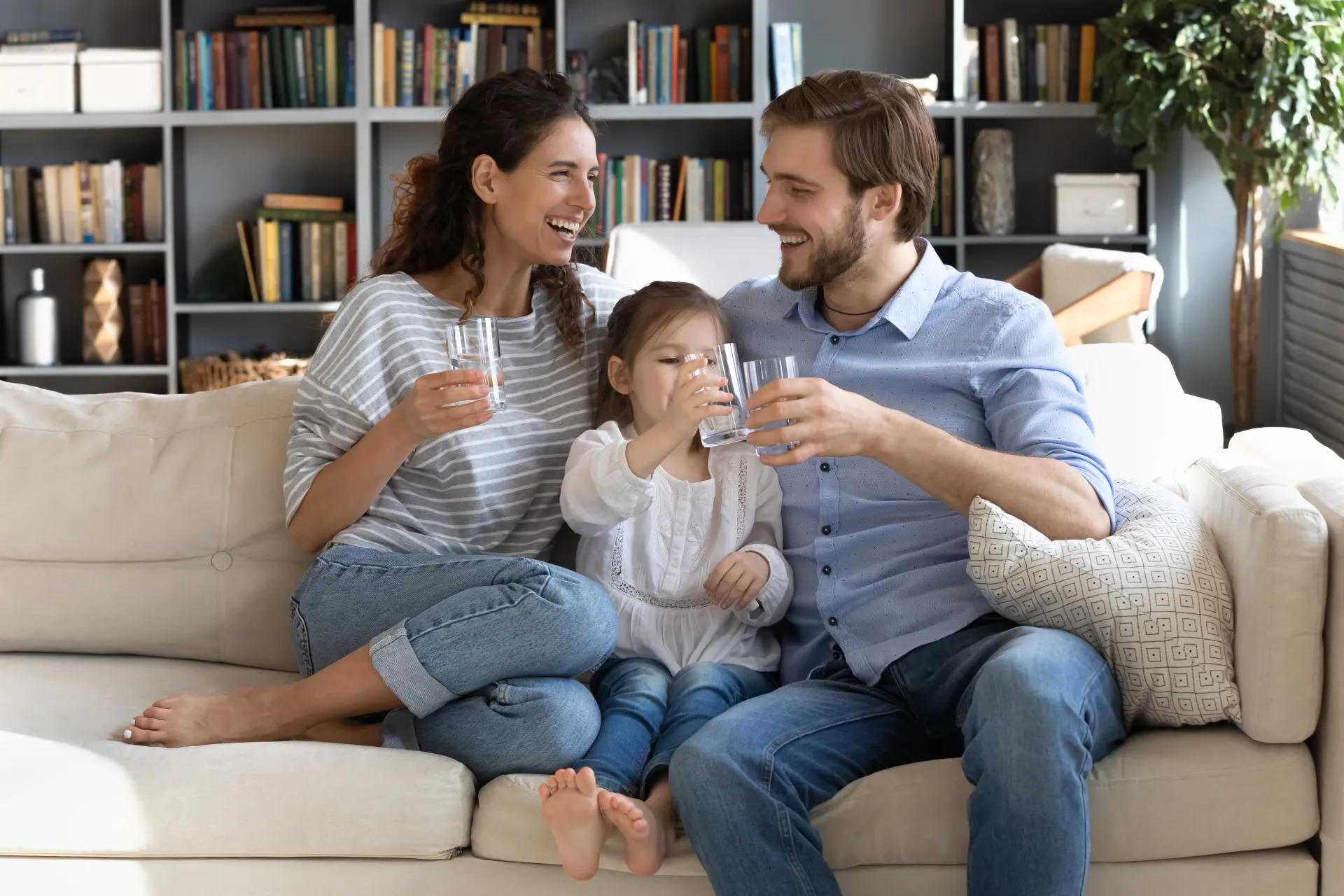 happy-young-couple-parents-teaching-little-preschool-daughter-drinking-clear-water-every-day-smiling-healthy-family-holding-glasses-with-pure-aqua-enjoying-morning-daily-healthcare-habit-home